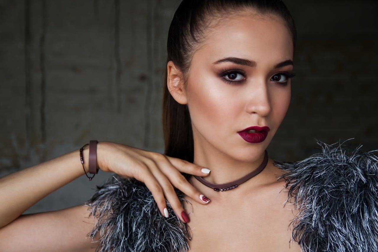 gallery-05 Close-up portrait of an elegant woman with bold makeup and fashionable attire, exuding confidence.