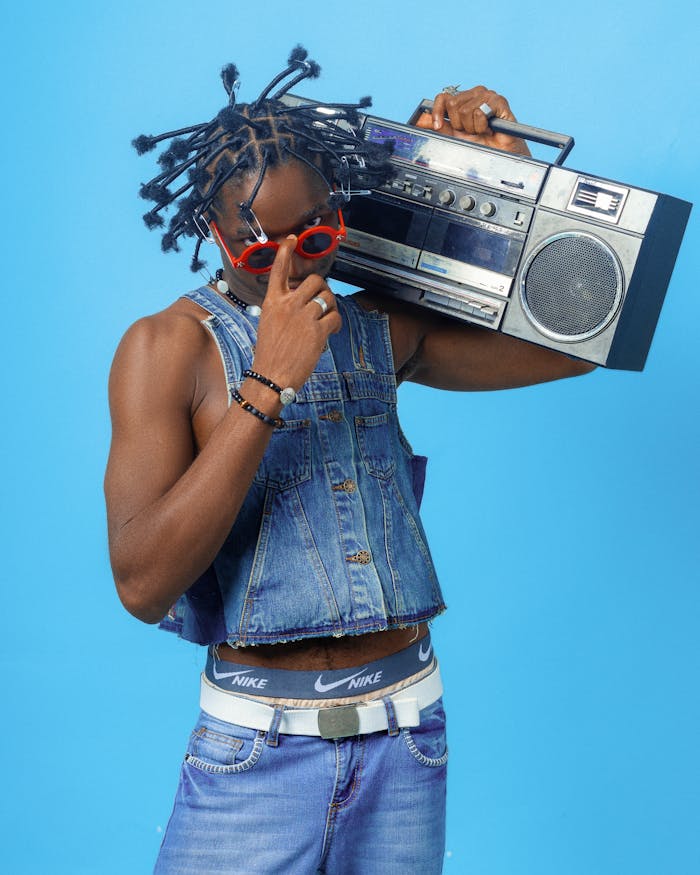 Fashionable man in denim with a vintage boombox, exuding retro 90s vibe.